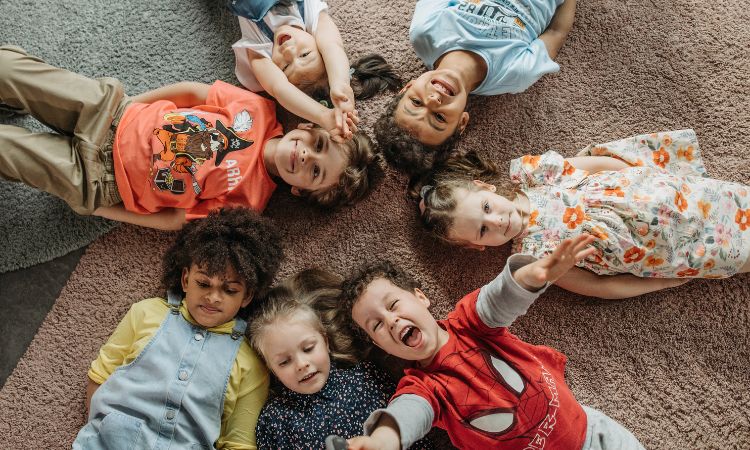 Children lying on the floor looking up at the camera